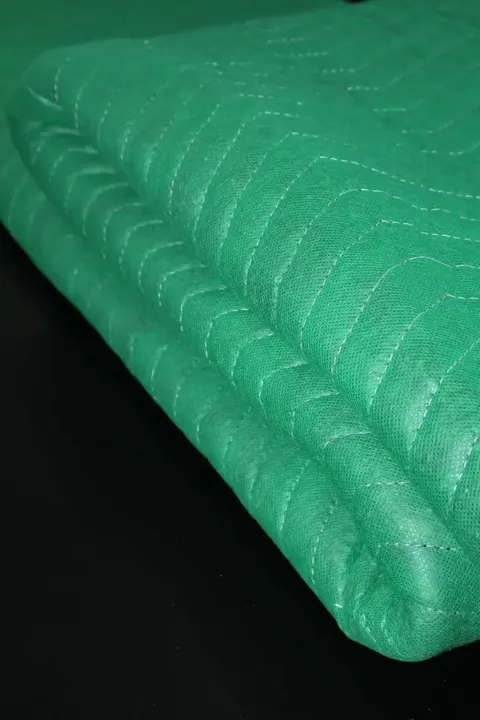 Green cotton moving pad quilted stitching close-up